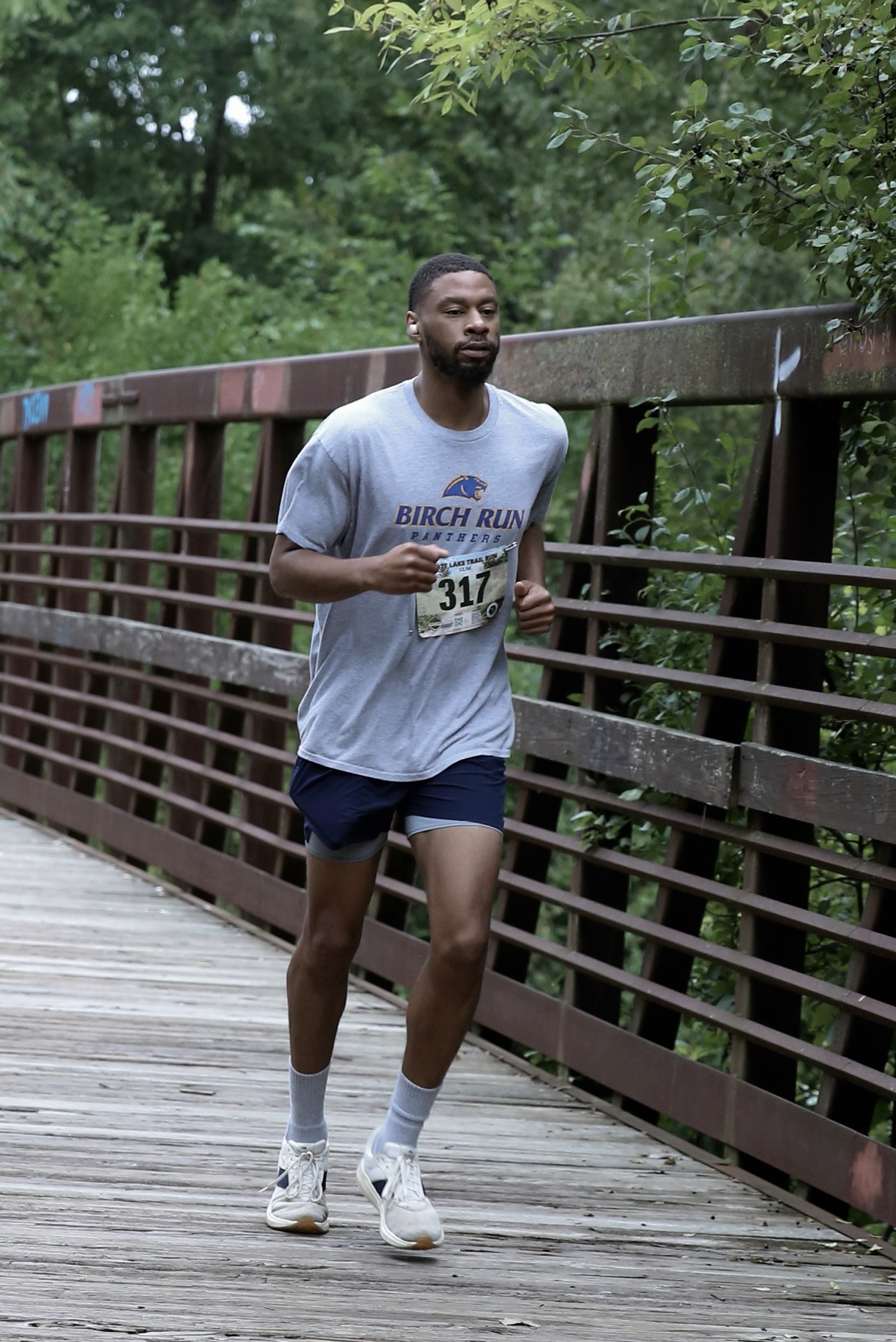 Chaz Johnson running across a bridge at the Mott Lake Trail Run